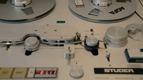 White vintage Studer A80 tape recorder with two large silver reels, control knobs, and branded labeling on professional audio equipment