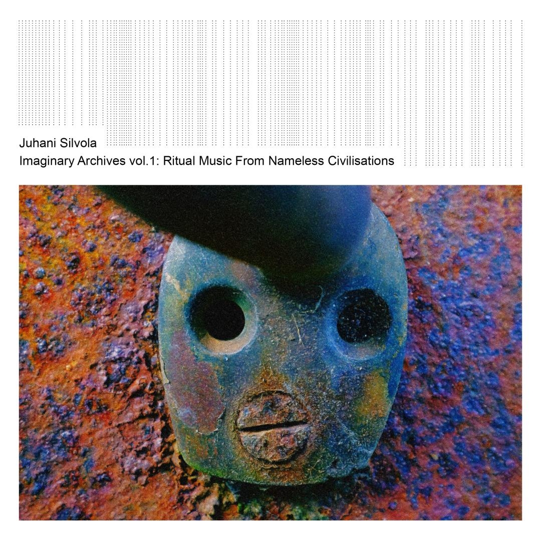 Ancient weathered mask with hollow eyes and open mouth sits among colorful corroded metal surfaces in blues, oranges, and purples, creating an eerie archaeological mood.