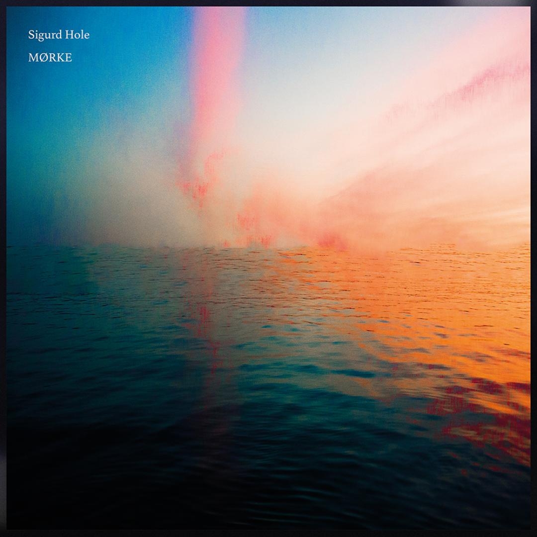 Dreamy seascape with gradient sky transitioning from deep blue to pink and orange hues, reflecting on rippling dark water below creating an ethereal, melancholic mood.