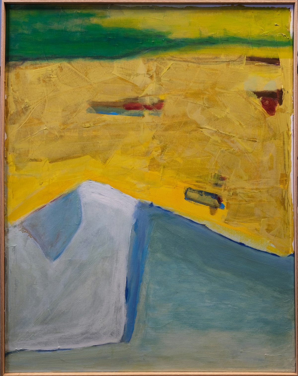 Abstract painting with yellow dominant upper portion, blue-white angular form in lower left, green horizontal band at top, red accent marks, in natural wood frame.