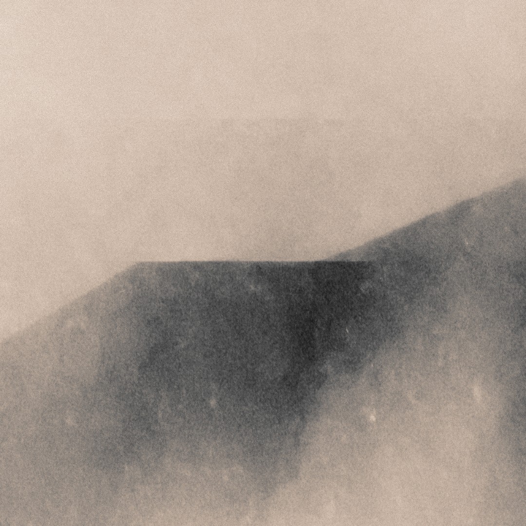 Misty mountain landscape with dark silhouetted peaks emerging through soft beige and gray fog, creating a dreamy, ethereal atmosphere.