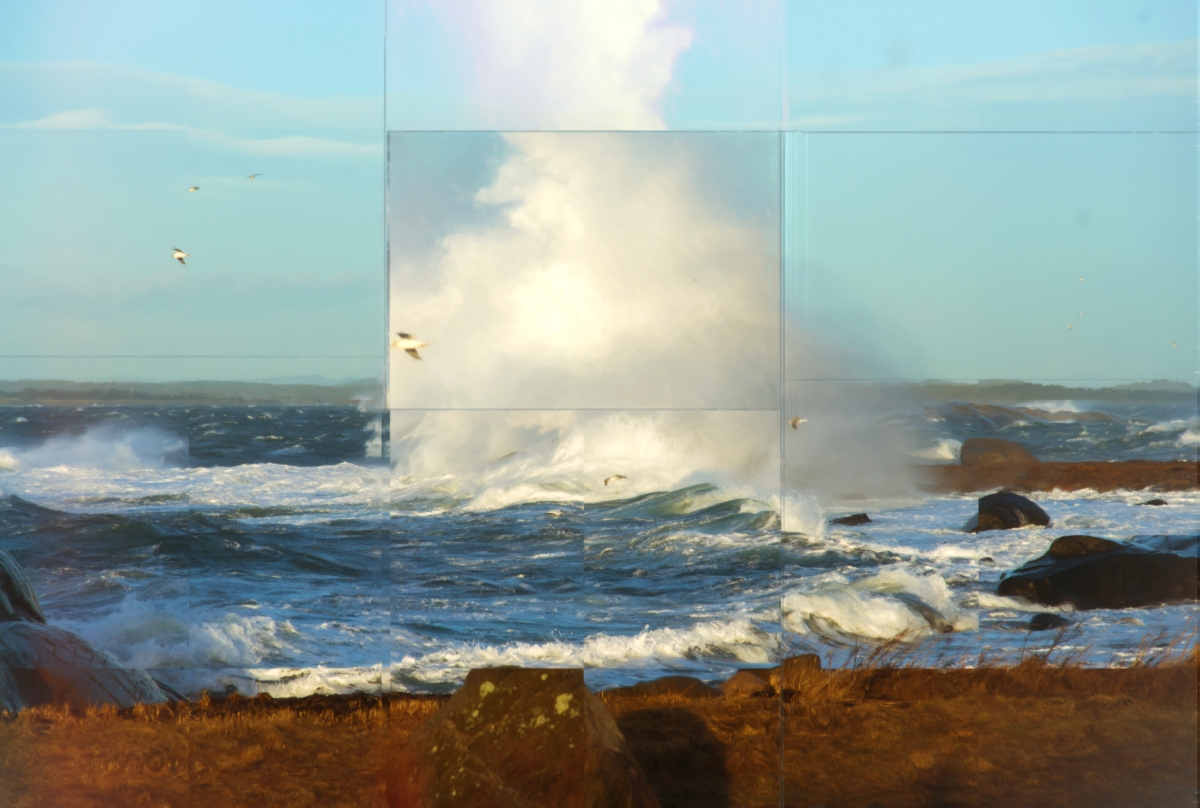 Dramatic ocean scene with large waves crashing against rocky shore, creating white spray plumes under cloudy blue sky with seagulls flying overhead.