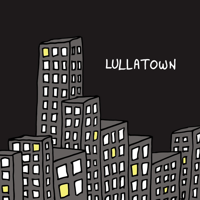 Dark cityscape with gray buildings and scattered yellow-lit windows against black sky, text "LULLATOWN" in white letters, creating a moody nighttime scene.