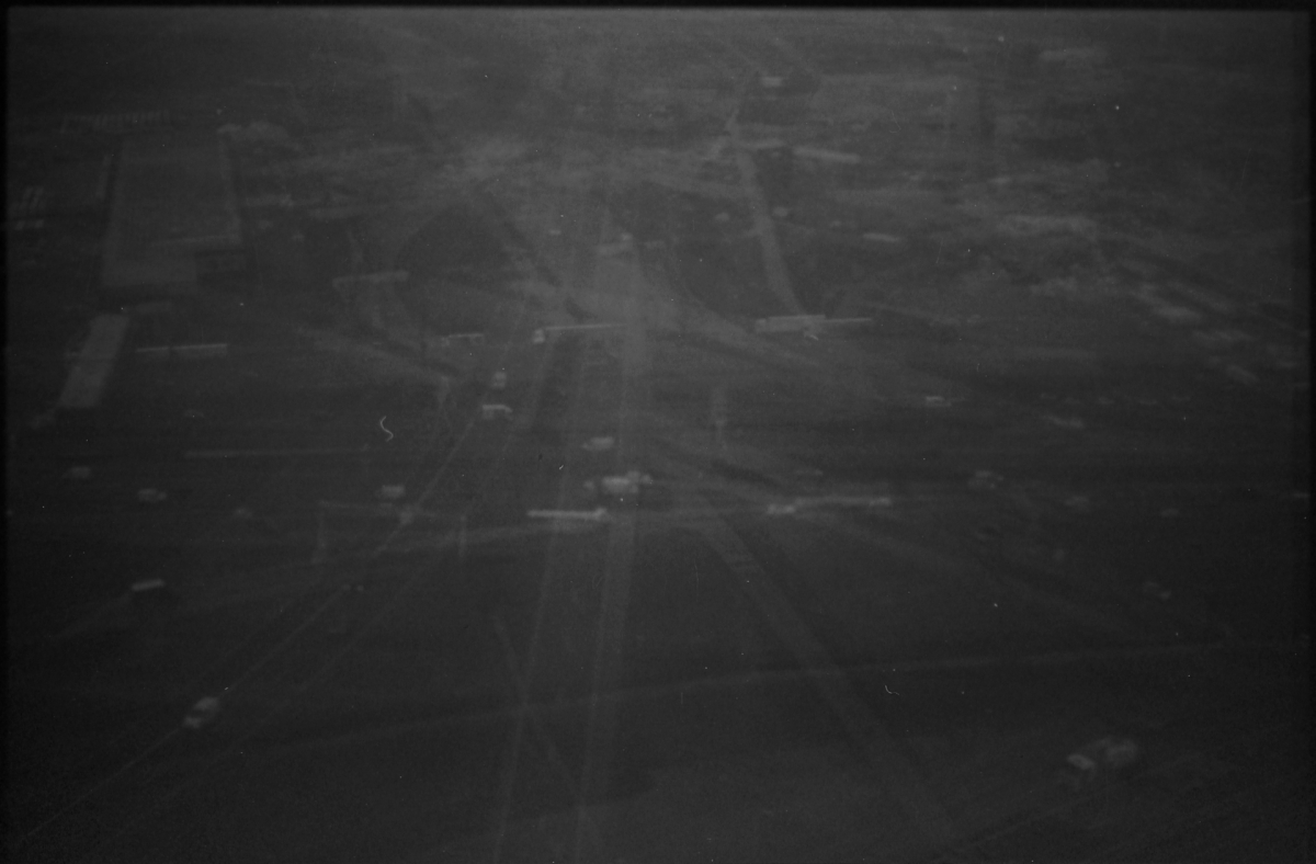 Dark, grainy black and white photograph showing blurred underwater or aquatic scene with indistinct shapes and murky, textured surfaces throughout the frame.