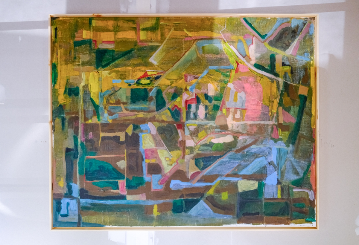 Framed abstract painting with geometric color blocks in ochre yellow, teal green, pink, and blue, evoking a fragmented cityscape or landscape.