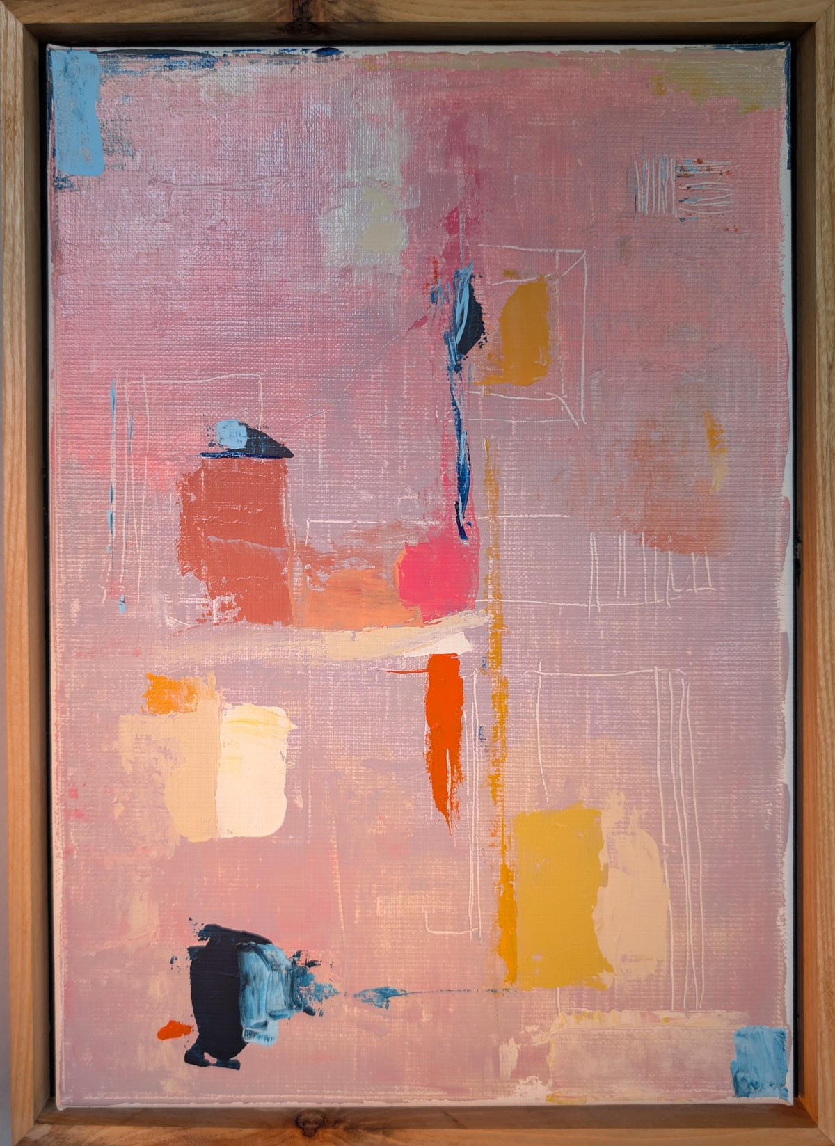 Abstract painting in a wood frame, pink background with blocks of blue, yellow, orange, red, and black paint arranged geometrically.