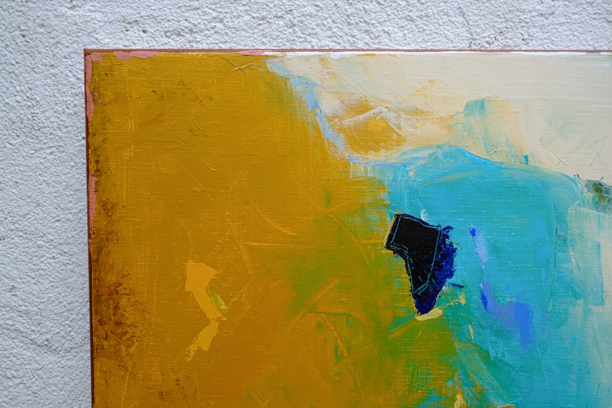 Corner detail of an abstract painting with bold mustard yellow, teal, and cream brushstrokes, accented by a dark navy shape, on textured wall.